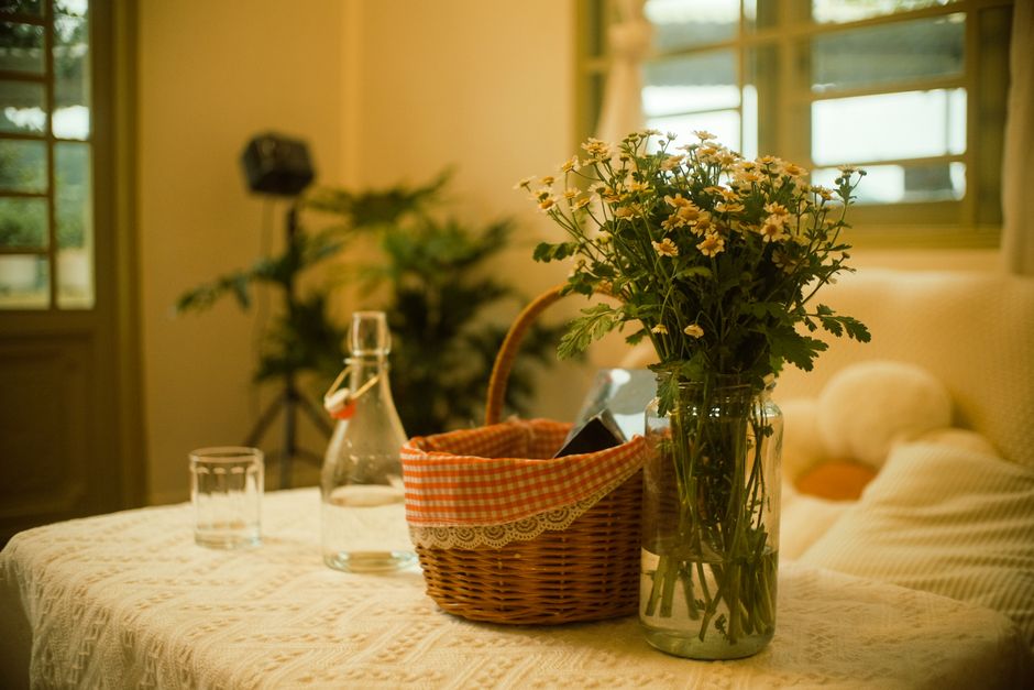 Zonnige keuken met vintage servies en bloemen.